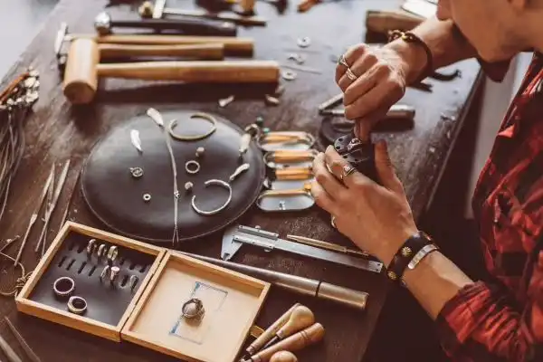Professional jeweler inspecting vintage family heirlooms at a traditional workbench in Milton.