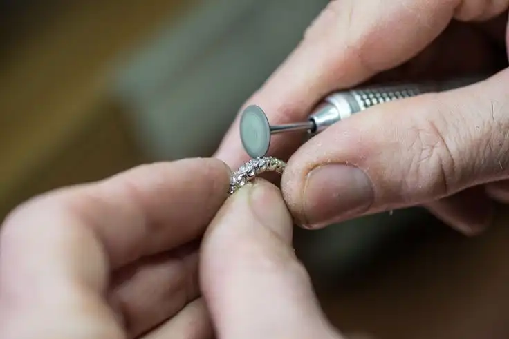 Professional jeweler using a rotary polishing tool to buff and shine a silver ring in Milton, Ontario.